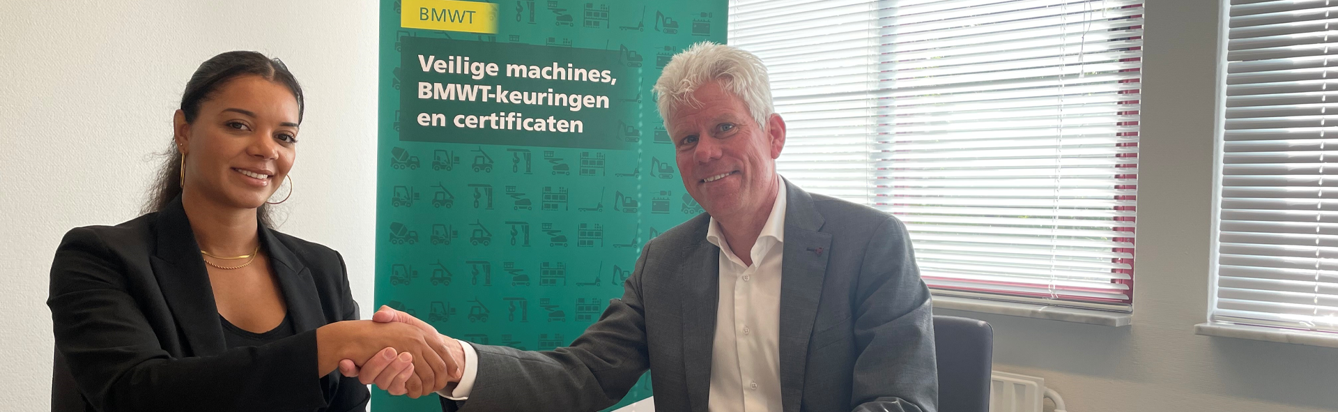 Een man en een vrouw schuden de hand om samenwerking DNV en BMWT-keur te bekrachtigen.