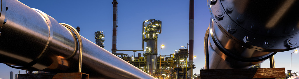 Een rood witte schoorsteen waar witte rook uitkomt tegen een strakblauwe lucht. 