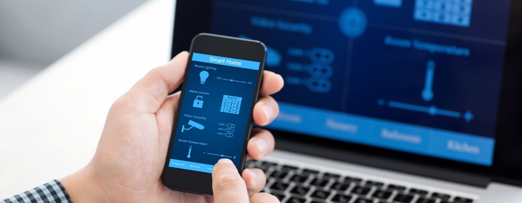 Man houdt een telefoon vast met een programma voor smart home op het scherm