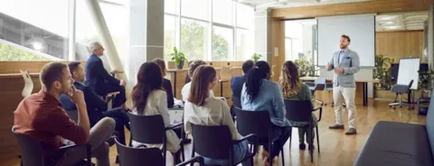 Mensen op een vergadering met een man vooraan