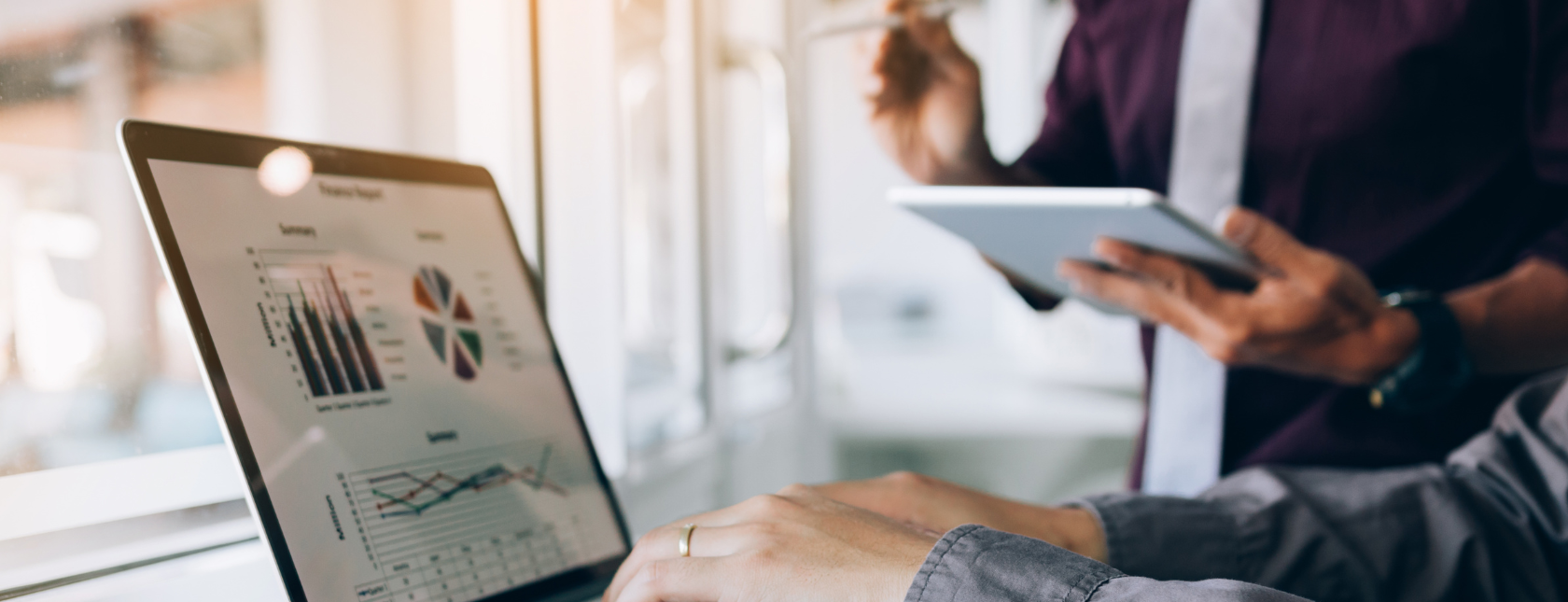 Twee professionals bespreken corrigerende maatregelen met gegevensgrafieken op een laptopscherm, met inzichten van lead auditor Matthijs Dierick van DNV.